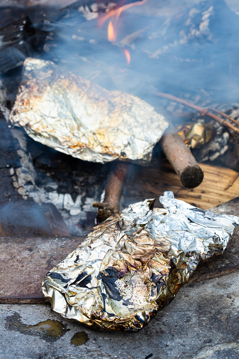 Cooking foil dinners in the coals of a campfire. 