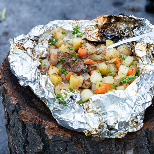 Making foil dinners in a campfire.