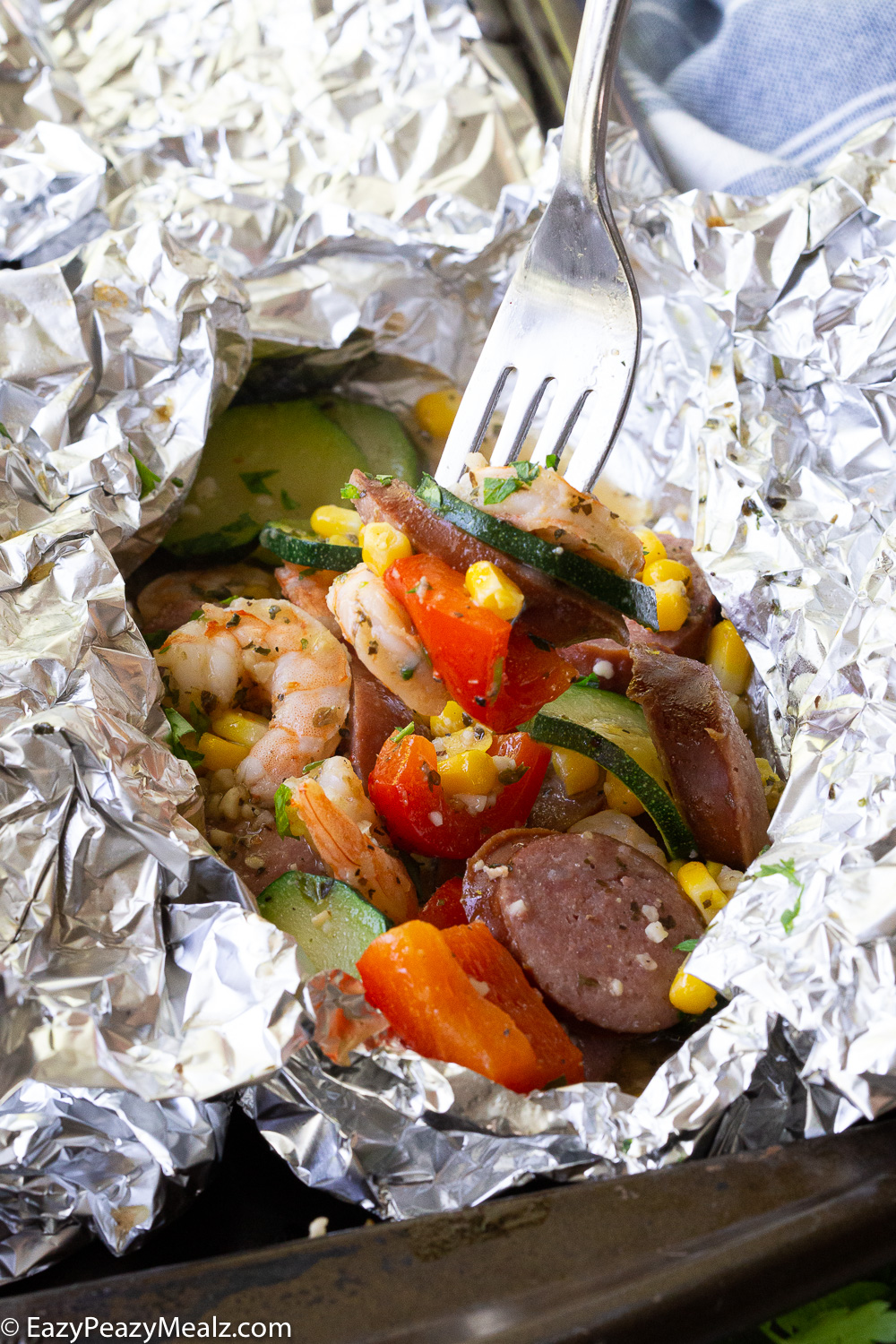 Shrimp and Kielbasa foil packs with red bell peppers, corn, and zucchini. 