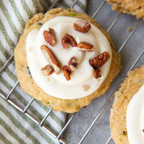 Zucchini cookies, a tender cookie studded with zucchini, and topped with cream cheese frosting and pecans.